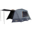 A gray OZtrail Fast Frame BlockOut 6 Person Tent with an extended awning set up outdoors.